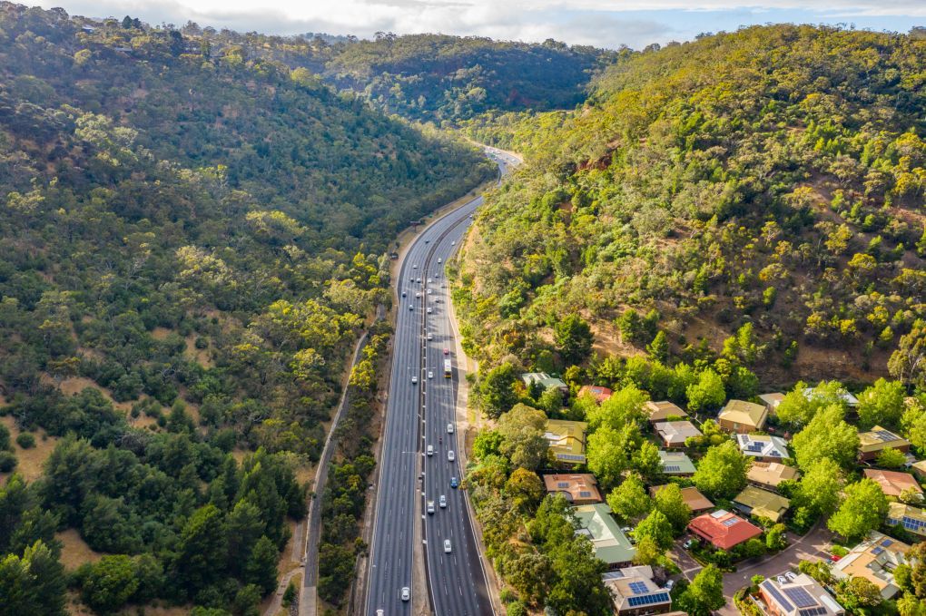 Freeway road with traffic on it and hills and trees either side