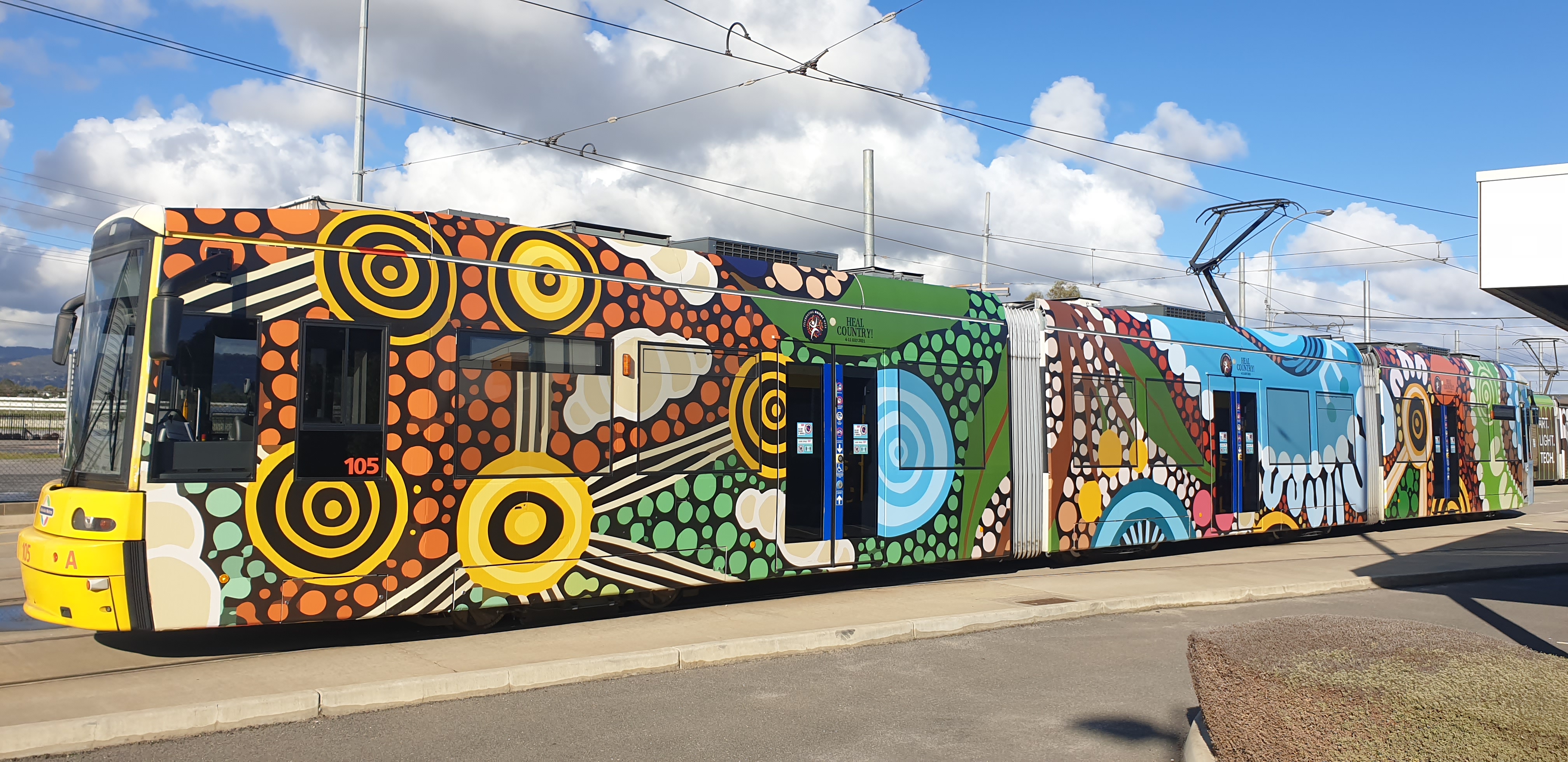 The Adelaide Metro NAIDOC Week tram is wrapped in the artwork of the 2021 National NAIDOC Poster, titled 'Care for Country'.