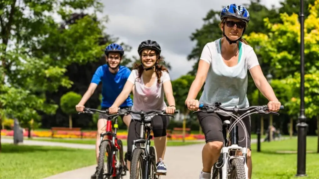 Two females and a male riding bike son a bike patth